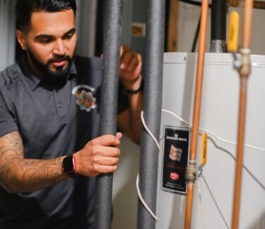 Technciain With Water Heater Lines